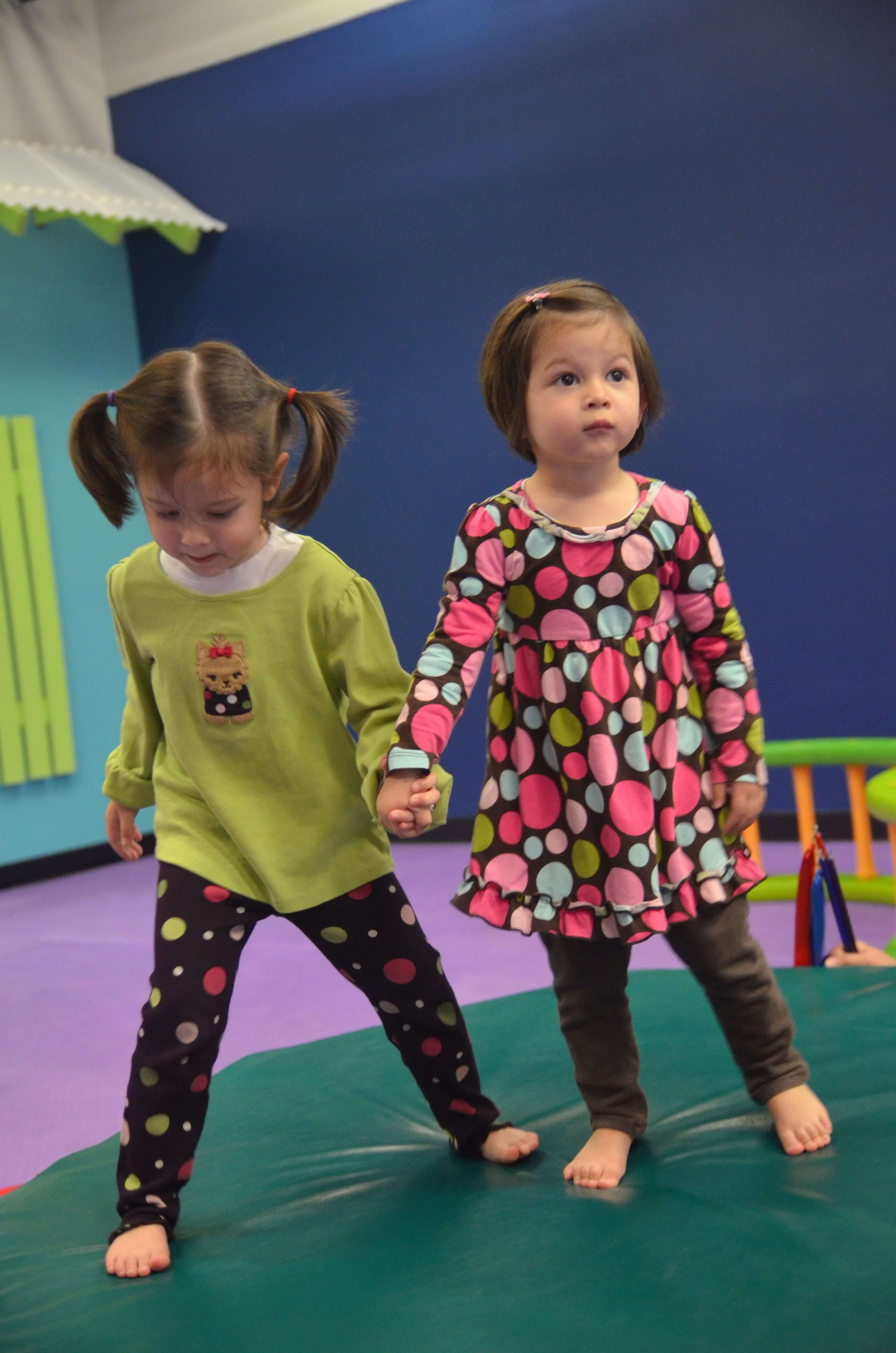 Two kids holding hands and playing indoors on a playdate - Romp n' Roll in Midlothian, VA