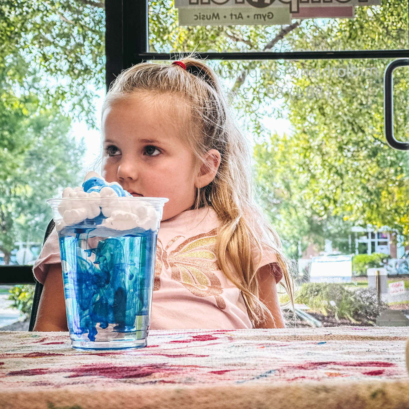 A little girl enjoying a blue drink, sign up for our affordable summer camps in Katy, TX.