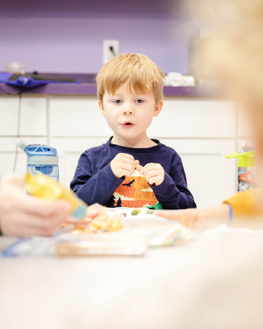 A child at Romp n' Roll enjoying the taste of food during Raleigh cooking classes for kids.