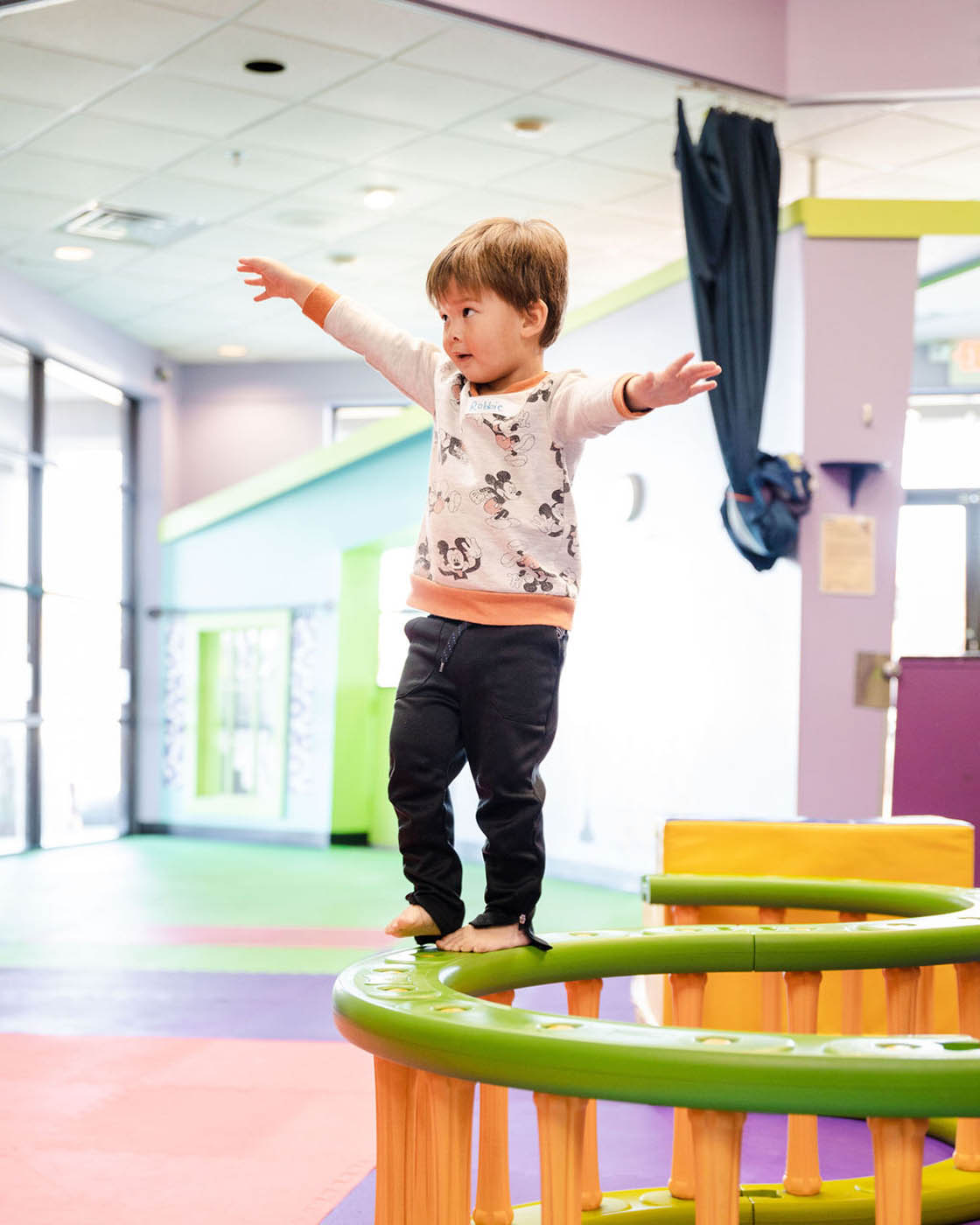 A little boy balancing on gym equipment, contact us today about our playgroup.