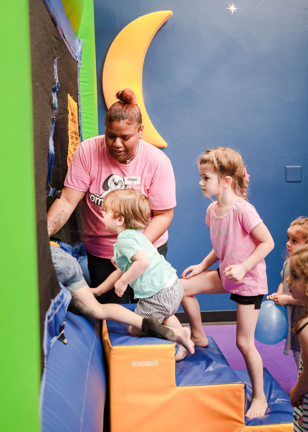 A Romp n' Roll instructor helping children play in our gym - we are a kids gym franchise!