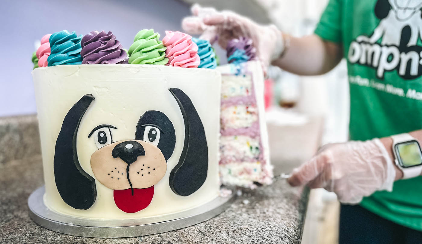 An image of a cake with rompy's face - Romp n' Roll is a top children's party venue!