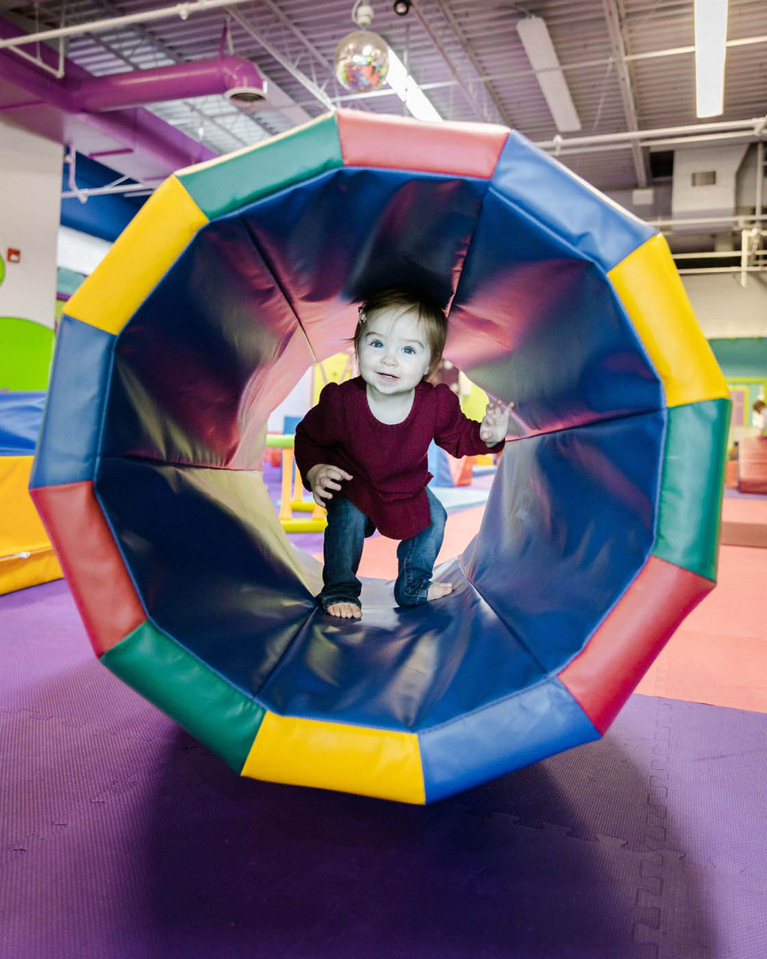 A little boy playing in Romp n' Roll's tunnel equipment, contact us today for trial class.