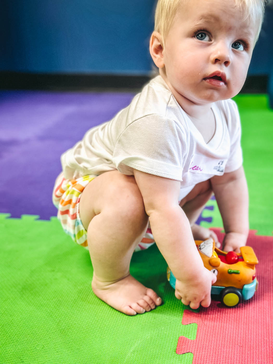 A baby boy playing at Romp n' Roll Katy kids gym, sign up for our baby classes in Katy, TX today.