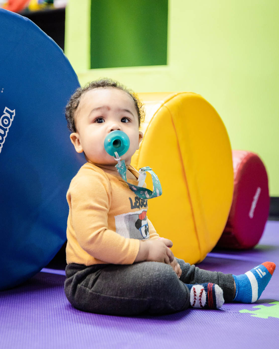 A baby playing with blow up balls, pick Romp n' Roll Midlothian today for your kids play area in Midlothian, VA.