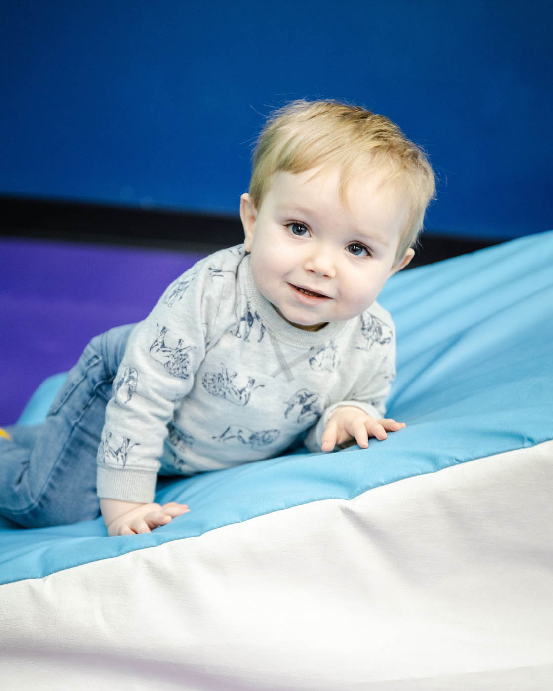 A baby boy taking advandage of Romp n' Roll St. Petersburg's baby gym.
