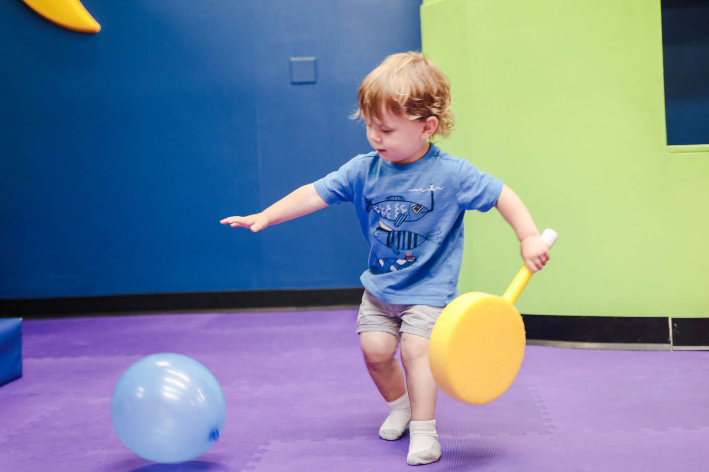 A toddler playing with a balloon at Romp n' Roll North Raleigh's classes for 2 year olds in Raleigh, NC