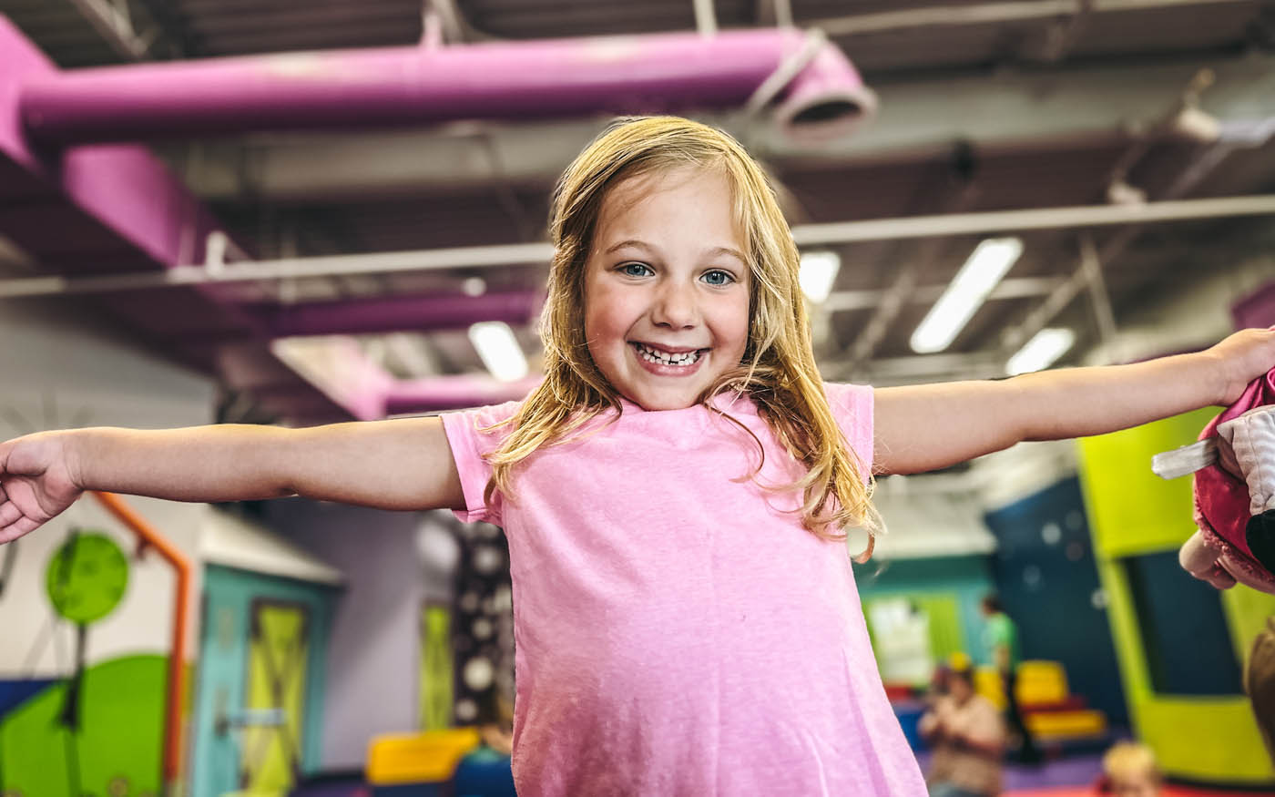 An about 5 year old girl playing in Romp n' Roll Northwest Charlotte's gym.