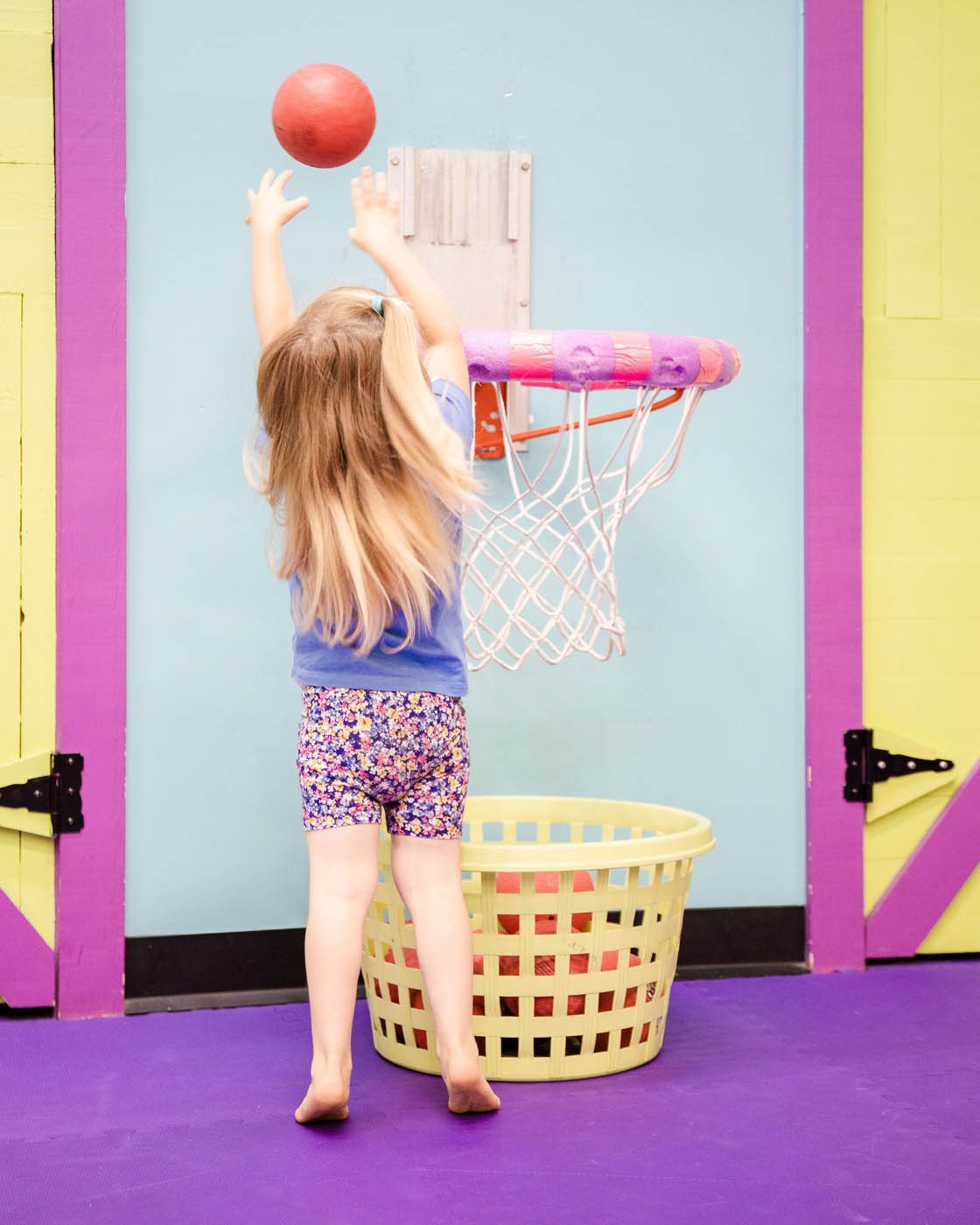 A little girl emjoying Romp n' Roll's sport focused class while playing basketball, contact us today for more toddler activities in Raleigh.