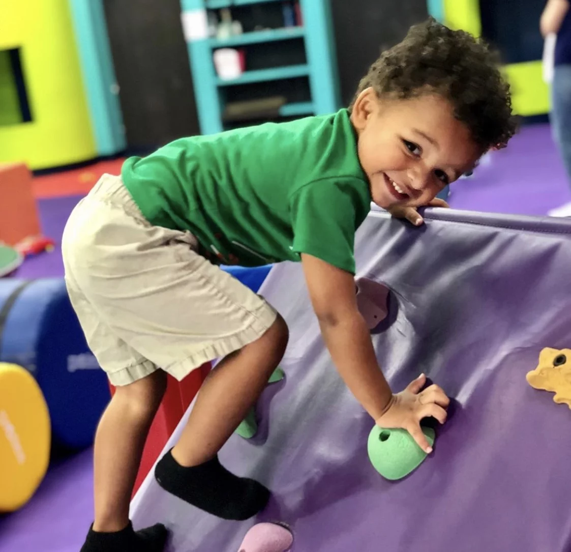 A little girl playing on Romp n' Roll's gym equipment, contact us today for our parents morning out event.