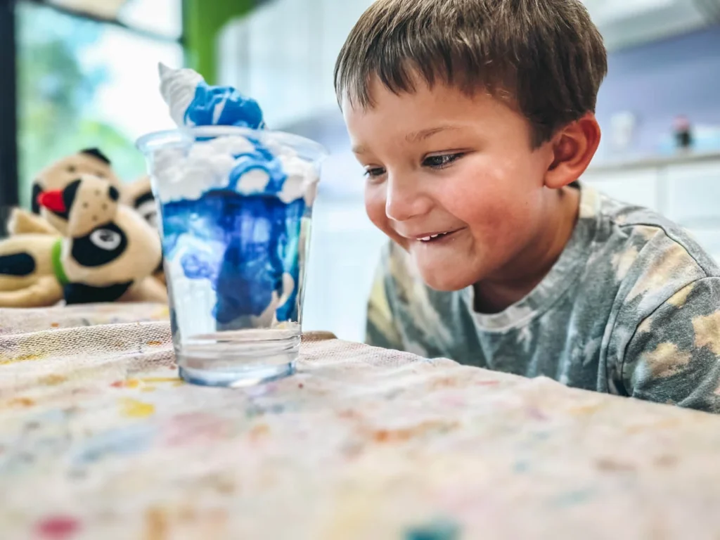 A little boy playing with water at science class at Romp n' Roll.