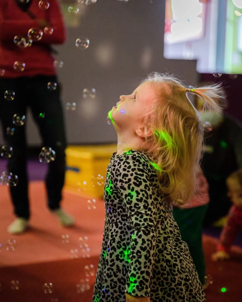 A young girl enjoying our music and bubble play classes at Romp n' Roll - our kids entertainment franchise.